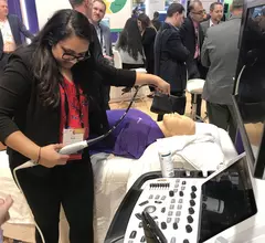 An attendee tries out a hands-on TEE simulator in a packed GE Healthcare booth at ACC.23. Photo by Dave Fornell