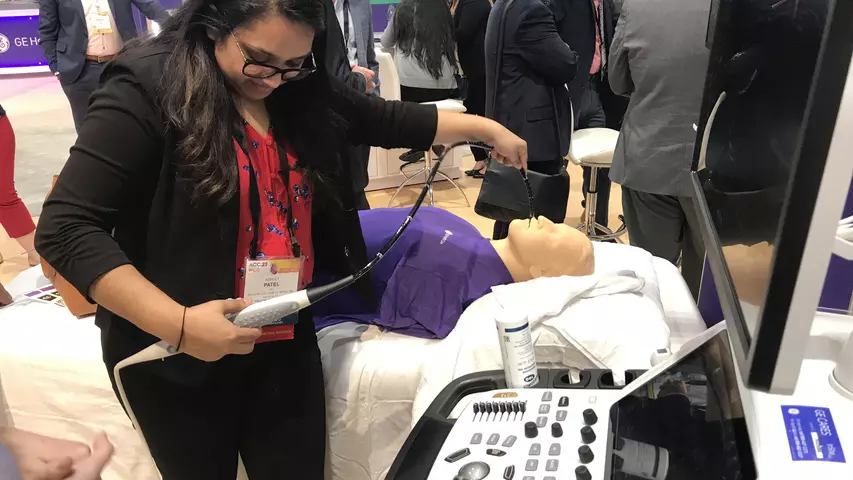 An attendee tries out a hands-on TEE simulator in a packed GE Healthcare booth at ACC.23. Photo by Dave Fornell