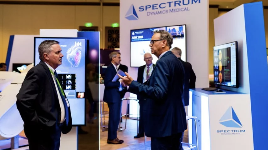 Discussion on the expo floor at the Spectrum Dynamics booth at ASNC 2024. Image courtesy of ASNC.