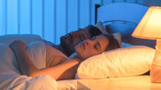 woman sleeps with lamp on
