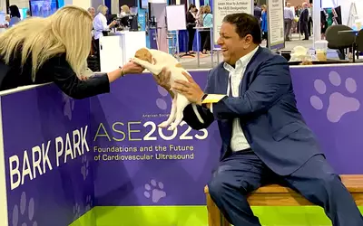 ASE 2023 attendees play with puppies at the Bark Park on the expo floor. Photo by Dave Fornell