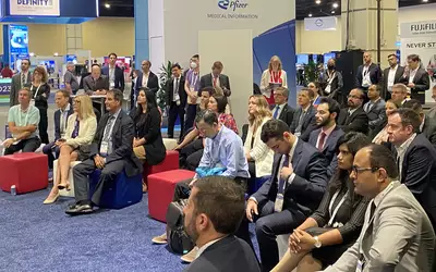 Crowd of attendees at AI session on ASE23 expo floor.