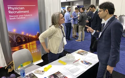 A recruiter from Prism Health in South Carolina speaks with an ACC.24 attendee on the expo floor. There is a growing shortage of general cardiologists and recruiters say it is getting more difficult to attract individuals to rural areas. Photo by Dave Fornell. #ACC24 #ACC2024