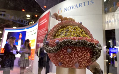 A cellular model in the Novartis booth promoting inclisiran (Leqvio) and attendees watching an augmented reality presentation in thye background. ACC23 DF 1